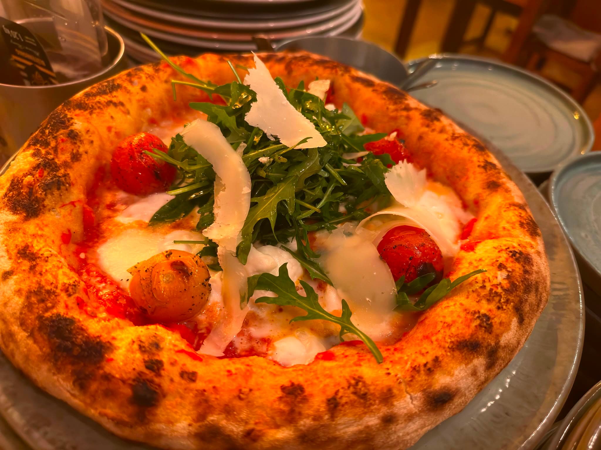 Pizza mit Rucola, Kirschtomaten und Parmesan
